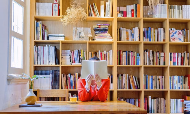 Woman reading a book in library.