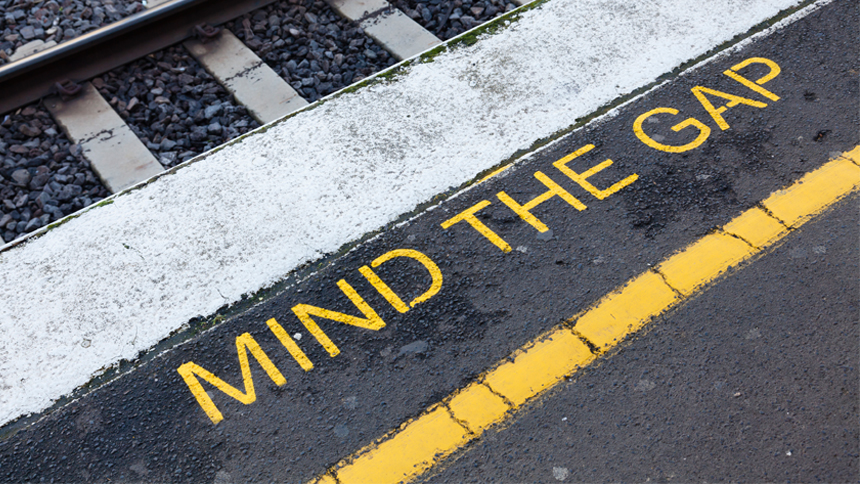 train stop with sign that reads mind the gap