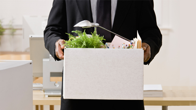 a professional boxing up his office belongings after leaving his job