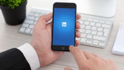 professional using LinkedIn on smartphone