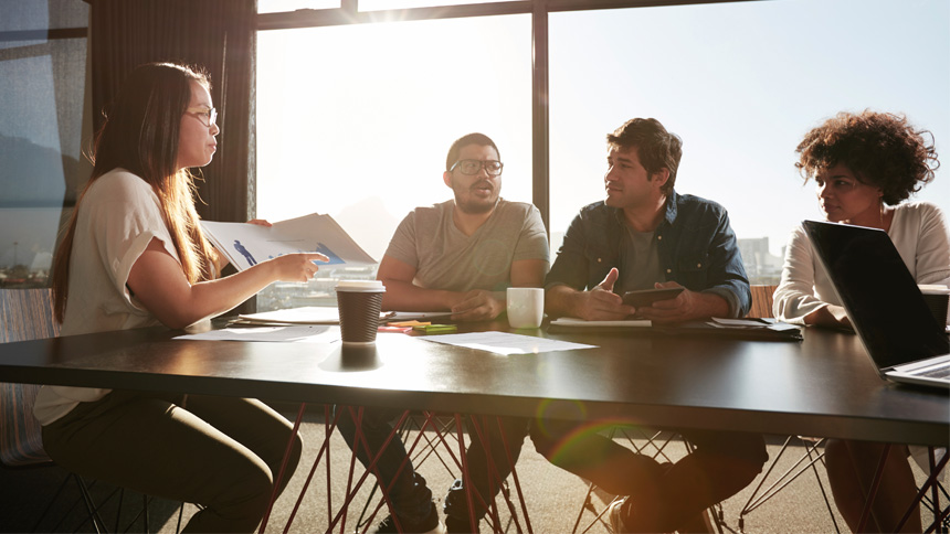 community manager and team sitting around a table