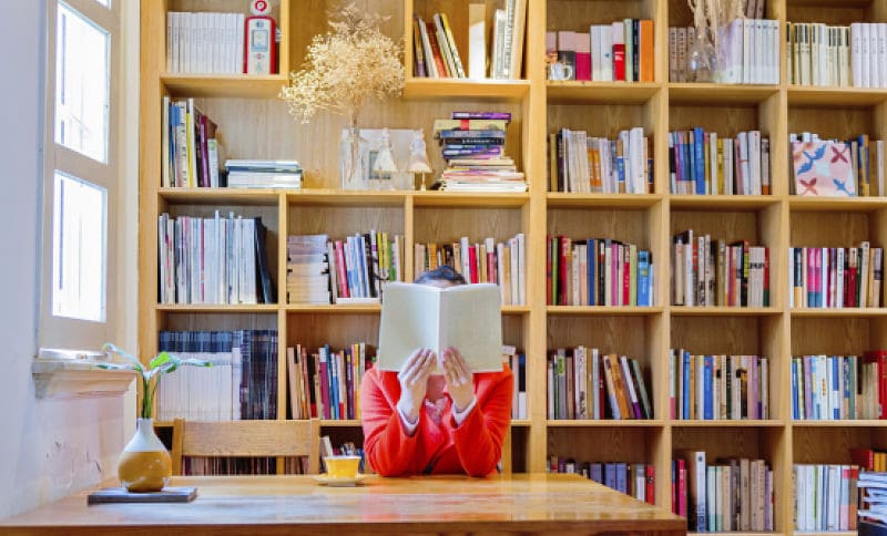 Woman reading a book in library.
