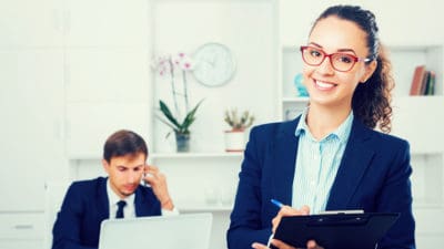 young woman manager holding clipboard in office