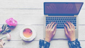 woman typing laptop tea flowers