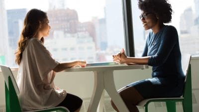 Two women in conversation at a table