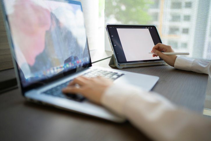 creative professional working on a computer with a stylist